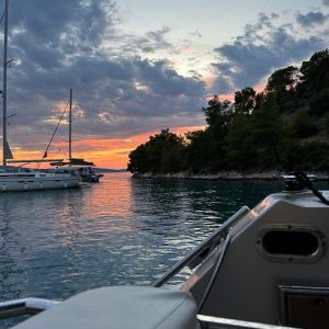 Yachts anchored in a quiet Adriatic bay at dusk.