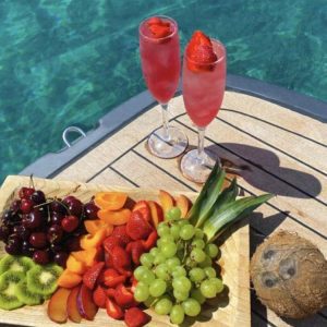Fresh fruit platter and cocktails on a yacht deck.